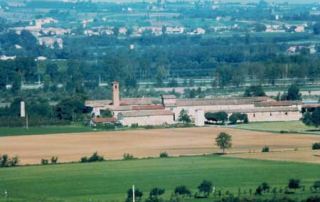 Una veduta della Corte di Giarola ripresa dalle colline di Gaiano. Il vasto complesso curtense si erge nella campagna a ridosso dell’alveo del fiume Taro (Foto U. Delsante, circa 1980)